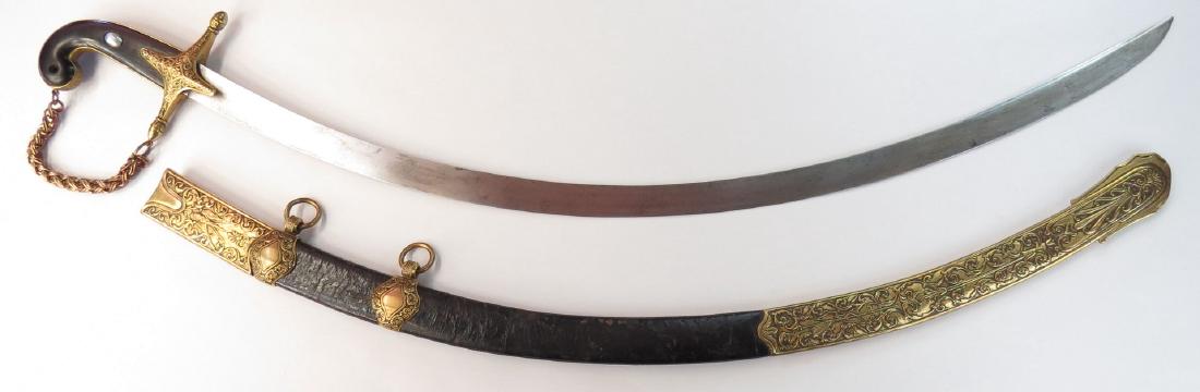 A SWEDISH GENRAL OFFICERS MAMELUKE-STYLE SWORD: The ebony grips with characteristic rolled pommel and inlaid with mother of pearl and knuckle chain. Mounted in gilt brass, the guard, locket, chape and suspension bands on the leather scabbard all el