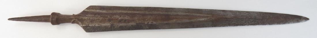 A MORO SPEARHEAD: Of characteristic form, the edged tapering continuously to the obtuse point, showing a fine pattern-welded damascus in the deep fullers, the base profiled, with spike tang. 19th century. Worn and pitt