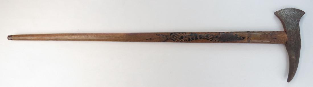 A HUNGARIAN FOKOS AXE: An older example, the massive steel head repurposed from a naval boarding axe. On its characteristically long carved hardwood haft with carved and painted decoration. 19th century. Head corroded. Over