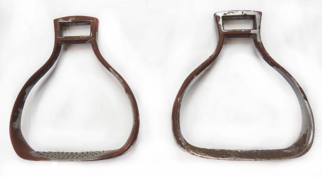 A PAIR OF IMPERIAL RUSSIAN CAVALRY STIRRUPS: Wrought of steel with rolled treads. Latter 19th century. Light wear. Overall height 16cm. Condition III