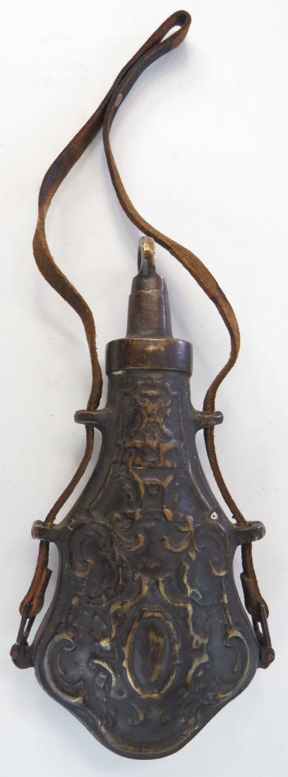 AN EASTERN EUROPEAN PRIMING FLASK: Bronze, cast with vegetal motifs. Retains its cap and leather strap. 20th century. Overall height 21cm. Condition III