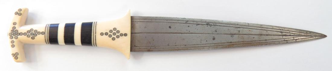 A RARE SUDANESE DAGGER: The grip of alternating sections of ebony and elephant stamped with birds eye motifs, the straight, double-edged leaf-shaped blade well-forged and grooved. 19th century. Minor wear. Overall length 26.