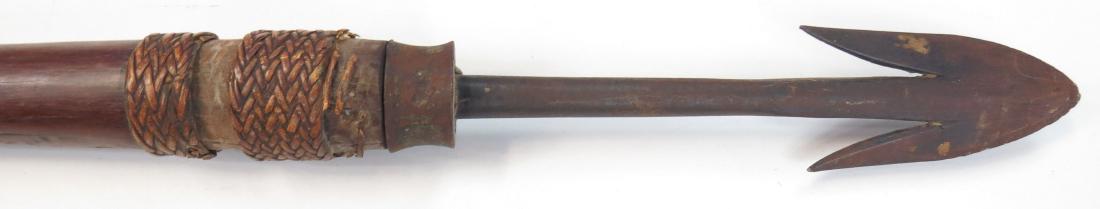 A PHILIPPINES FALFEG SPEAR: Igorot People, the heavy, barbed fighting head handforged, with metal ferrule and tapered hardwood haft. Late 19th century. Worn. Overall length 156.2 cm Condition II