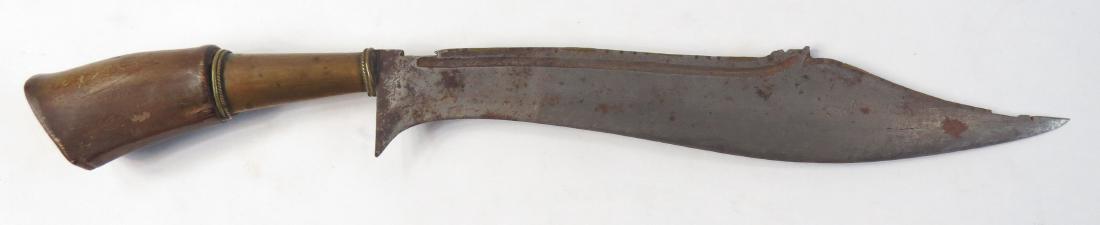 A BALINESE WEDUNG KNIFE: With rhino grip and long brass ferrule with beaded edge, the exceptionally broad blade of characteristic form, profiled and inlaid with brass at the spine, with a short fuller and substantial clipped 
