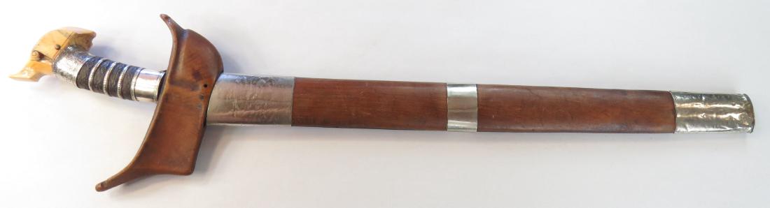 A MORO DATUS SWORD KRIS: The elaborately-worked junggayan hilt typically carried by a datu or noble, with elephant kakatua-form pommel and silver mounts embellished with okir engraving and filigree interspersed with woven cor