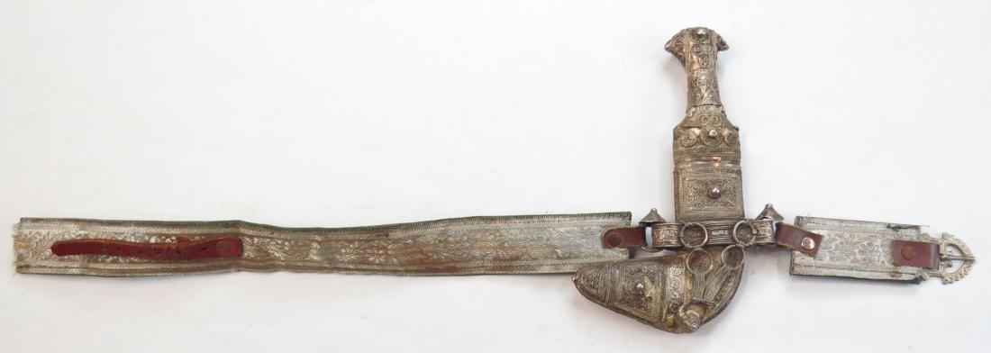 AN OMANI CHILDS KHANJAR DAGGER: Of typical form, mounted entirely in filigreed silver. The curved, double-edged blade with central rib, wooden scabbard covered entirely in filigreed silver en suite with the hilt. The embroidered bel
