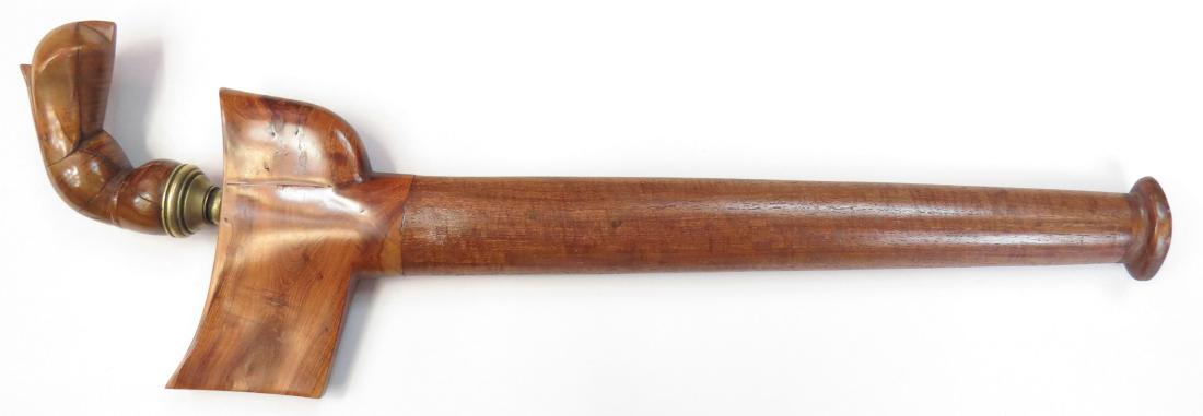 A SULAWESI KRIS SWORD: Of characteristic Bugis form, the grip and scabbard carved of exotic hardwood with good patina. With brass mendak, the broad, straight blade showing an old and active damask. Mid-19th century. Age che
