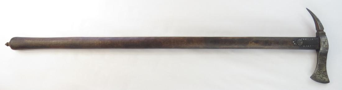 A HUNGARIAN FOKOS AXE: An older example, the massive steel head with spike peen, and engraved with the owner’s initials. On its characteristically long hardwood haft with iron nailhead decoration. 18th-19th century. Well 