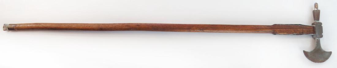 A HUNGARIAN FOKOS AXE: An older example, the massive head with spike peen. On its characteristically long hardwood haft. 19th century. Well worn. Overall length 87.2cm. Condition III