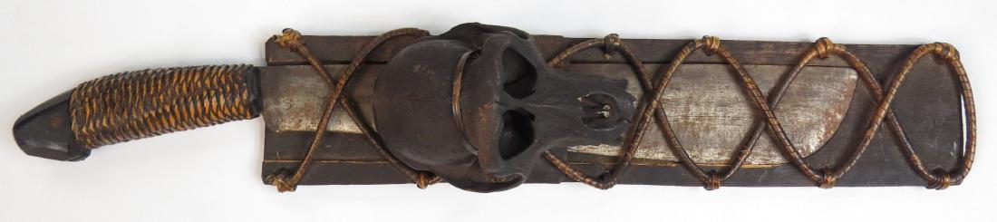 A PHILIPPINES PINAHIG KNIFE: Ifugao People, with broad, handground, single-edged blade struck BR, and rattan-wrapped grip with horn pommel. In its characteristic profiled wooden scabbard bound with rattan and decorated with a sku