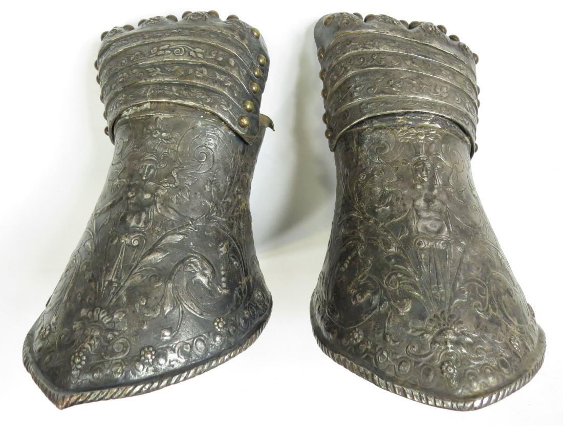 A FINE PAIR OF ARMOR ELEMENTS GAUNTLETS: The work of a French master, perhaps intended for parade. Wrought entirely in silvered copper, embossed and engraved throughout with Mannerist motifs involving mythological characters, brass studs. 17
