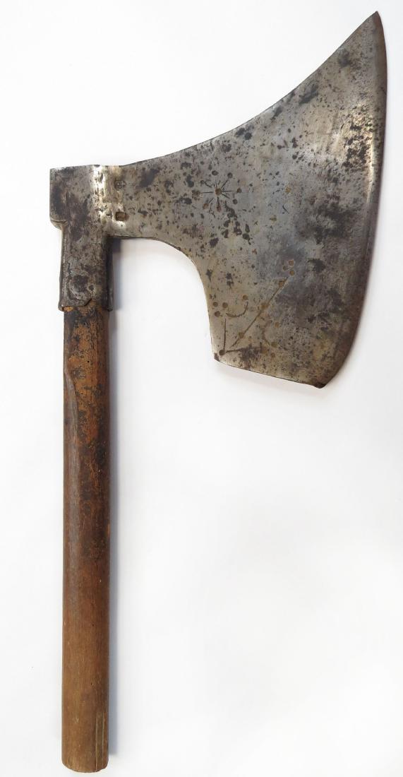 A GERMAN BEHEADING AXE: The massive head of characteristic form, well forged with distinct beard and rectangular poll; struck with a pair of maker’s marks and numerous geometrical stamps. Retains its rare original haft sho