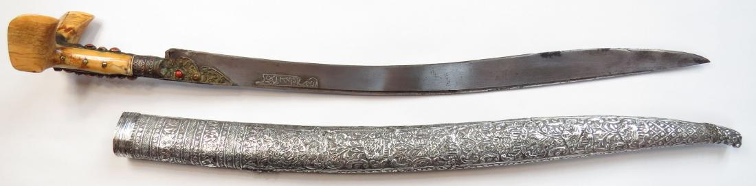 AN OTTOMAN YATAGHAN SWORD: An exceptional example, with massive walrus grips of Balkan form, the gilded tangband and bolsters set with corals. The broad, single-edged recurved blade with narrow fuller, inscribed in a silver car