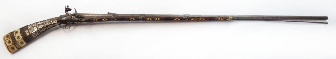 A DZEFERDAR MUSKET: An early example of the type, based upon an Italian longarm which evolved in Boka Kotorska, Montenegro. Stocked in dark hardwood and elaborately inlaid in mother of pearl, with brass medallions and ot