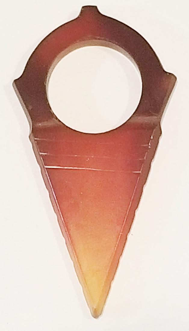 A TUAREG ARCHERS RING: Of characteristic triangular form, handground of carnelian and well polished. 19th c. Overall length 7cm. Condition I