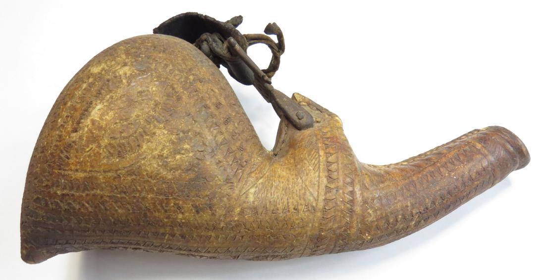 A PERSIAN BARUTDAN POWDERHORN: Of tooled rawhide with strap and buckle intact. Mid 19th century. Overall length 28cm. Condition III