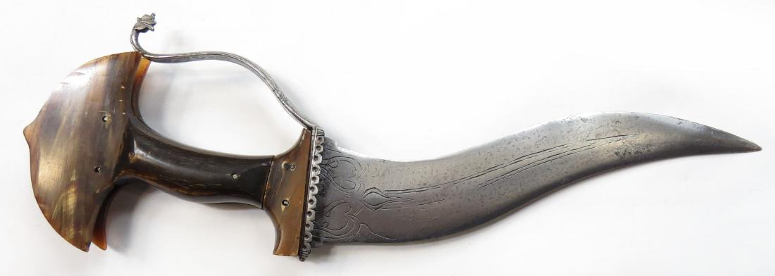 AN INDIAN KHANJARLI DAGGER: A robust example of classic form, the grips carved of horn with characteristic broadly flared and cusped pommel. With profiled, pierced bolsters and integral knucklebow terminating in a monster head,