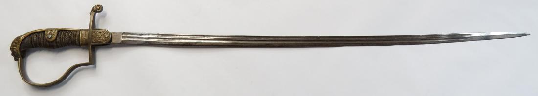 A GERMAN OFFICER’S SWORD: With lionhead pommel P-guard and bakelite grip retaining its sharkskin covering and twisted brass wires. Single-edged, fullered blade. Late 19th century. Wear and minor losses. Overall length 86.4cm. 