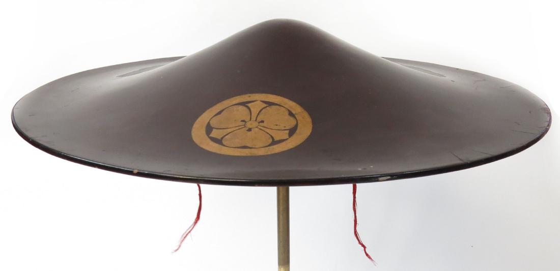 A FINE JAPANESE JINGASA RETAINERS HELMET: Of characteristic form, black lacquered with gold mon. The interior crimson. Edo Period (early 17th-latter 19th century.) Minor chipping. Diameter 39cm .Condition II