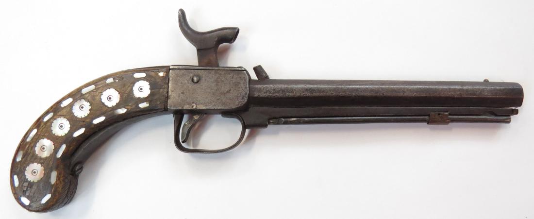 AN AFGHAN PERCUSSION PISTOL: A large example based upon a British prototype, with walnut grip inlaid with mother of pearl, with steel frame and octagonal barrel with triggerguard and ramrod. Latter 19th century. Worn. Overall len