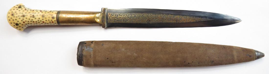 A BOSNIAN DAGGER: Sarajevo work, the bone grips inlaid with brass rosettes and studs. The broad, double-edged blade with extensive gold-inlaid panel including, WORK OF HASSAN / YEAR 1879. In its wooden scabbard. Dated 