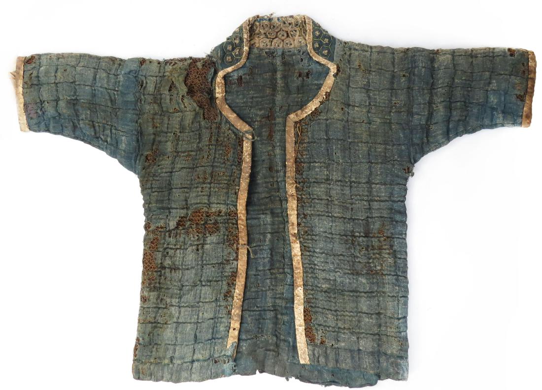A JAPANESE KUSARI KATABIRA CONCEALED ARMOR: Rarely encountered, an Edo-era samurai garment of padded blue cotton fabric, enclosing a full coat of mail, with high, studded collar, and leather-lined opening and sleeves. Latter 17th century. Losse