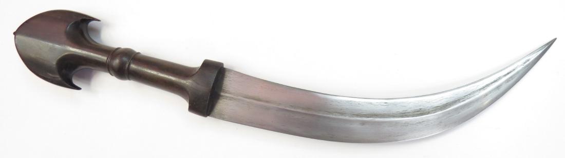 AN IRAQI DAGGER: Of characteristic Marsh Arab form, with well-carved horn grip, the curved, handforged blade with central ridge. Latter 19th century. Overall length 35.5cm. Condition II