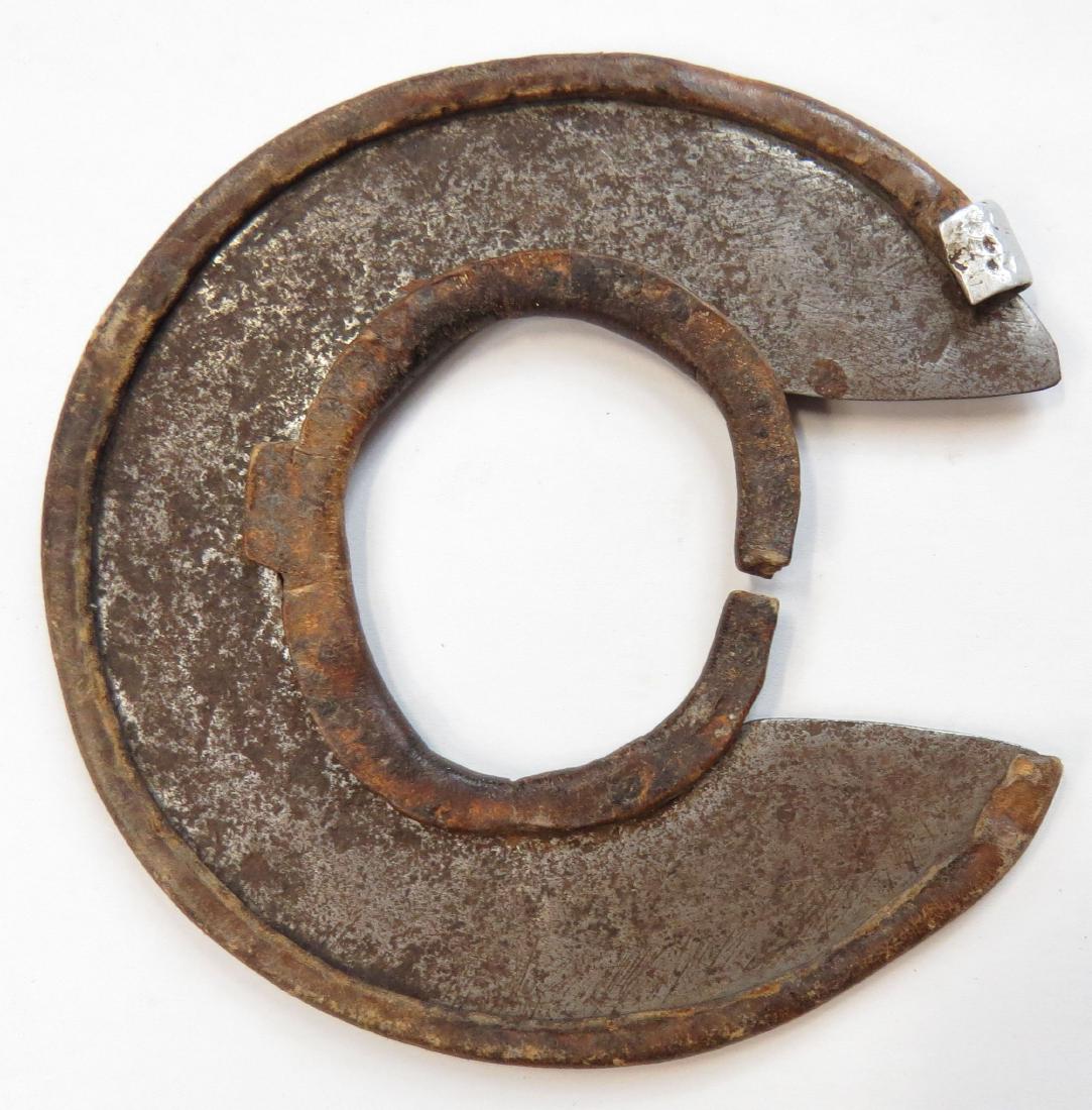 AN AFRICAN WRIST KNIFE: Kenya, Turkana People, the circular blade well-wrought and edged. with its hide blade guards intact. First half of the 20th century. Diameter 10.4cm. Condition II