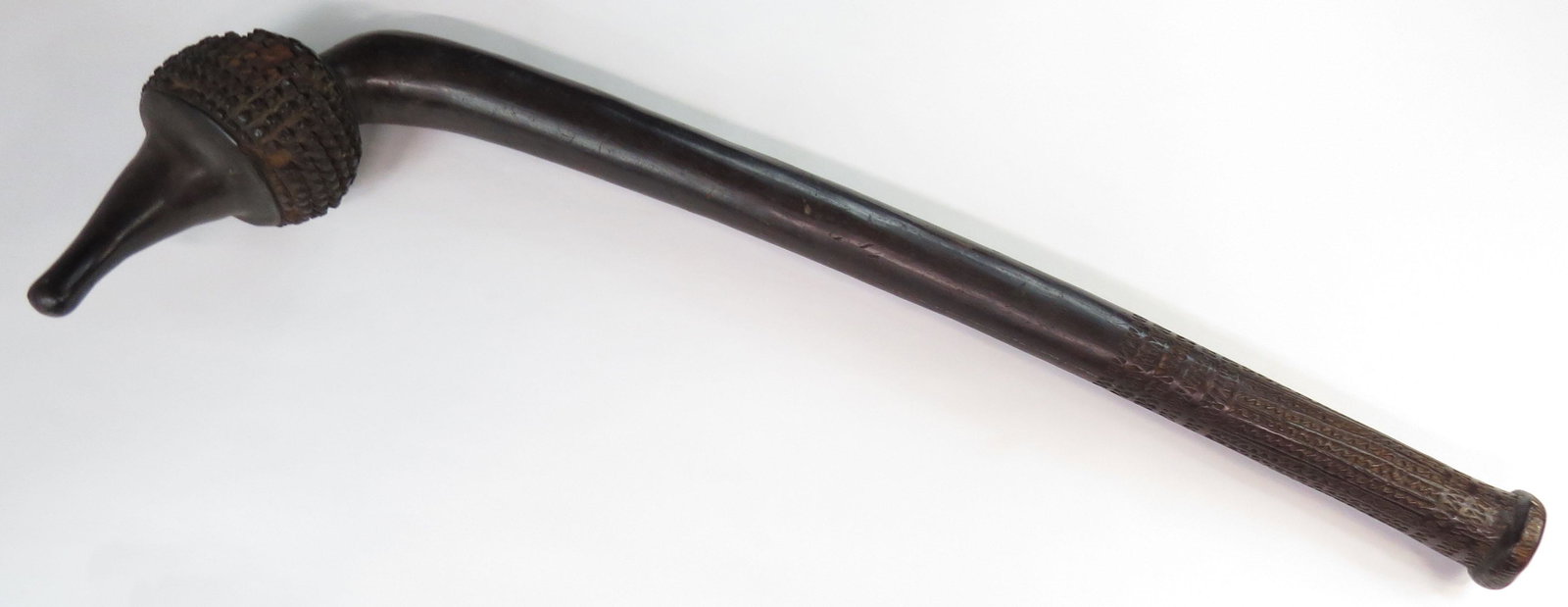 A FIJIAN TOTOKIA WARCLUB: A massive example of characteristic form with well-carved head composed of a spiked sphere on a long, thick haft. 19th century. Worn overall with minor losses. Overall length 77cm. Condition III