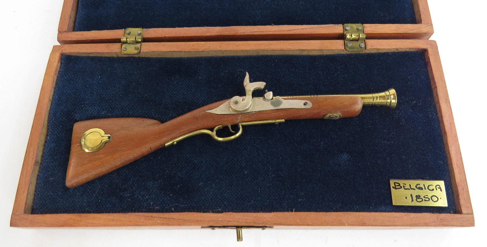 A MINIATURE BELGIAN BLUNDERBUSS BY EDUARDO RUIZ: A miniature Belgian blunderbuss made entirely by hand, the stock carved of hardwood with patchbox and percussion mechanism, barrel and trigger all superbly detailed in metal. In its fitted handmade ha