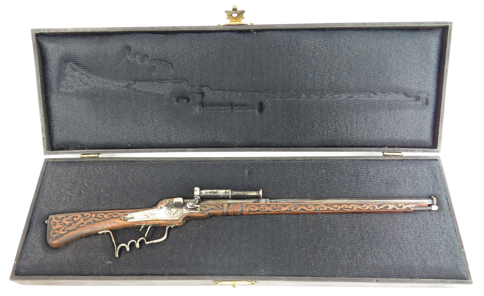 A FINE MINIATURE WHEELLOCK RIFLE BY EDUARDO RUIZ: A miniature wheellock breechloading rifle made entirely by hand, the stock carved of hardwood with percussion mechanism, barrel, triggerguard and appliques all superbly detailed in metal. In its fitte