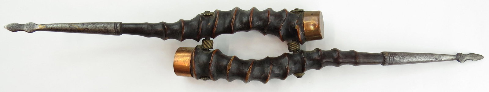 AN INDIAN FAKIR’S WEAPON: A pair of joined blackbuck antelope horns with brass caps and wrought steel spikes at the ends. 18th-19th century. Minor wear. Overall length 43cm. Condition III
