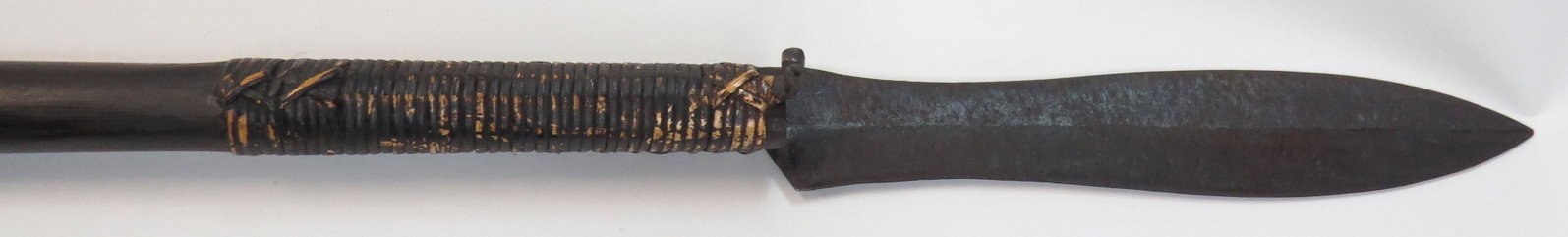 A DAYAK SUMPITAN BLOWGUN: The characteristic wooden haft hollowed for darts, the mouthpiece lined with resin, a well-formed spearhead bound to the tip with rattan as is typical. First half of the 20th century. Overall length 2