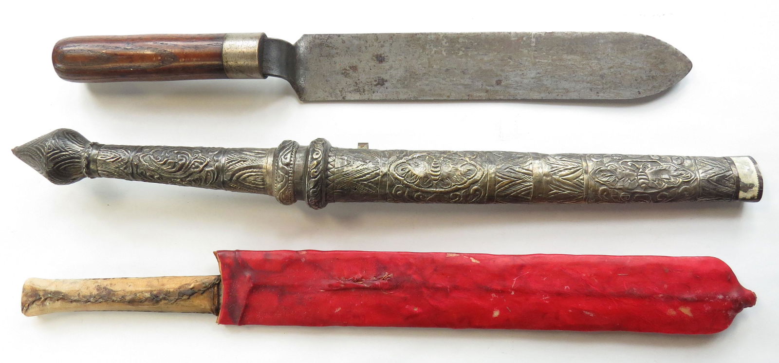 THREE EDGED WEAPONS: A decorative dha, a Maasai seme, and a military tool (?) 19th-20th century. Worn. Overall length of longest 55cm. Condition III