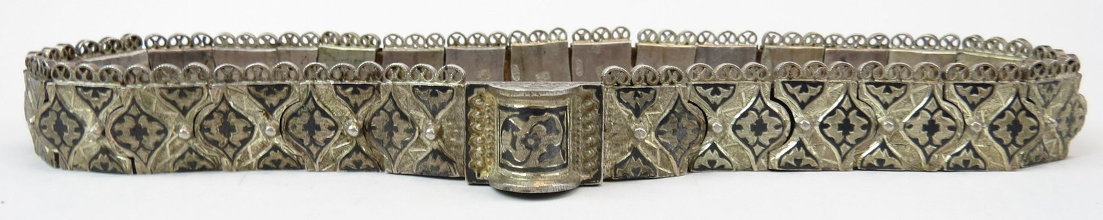 A CAUCASIAN SILVER BELT: Georgian or Armenian work, made entirely of linked silver plaques with elaborately chiseled and nielloed motifs overall. The reverse of each hallmarked. 19th century. 40cm in overall length. Condition