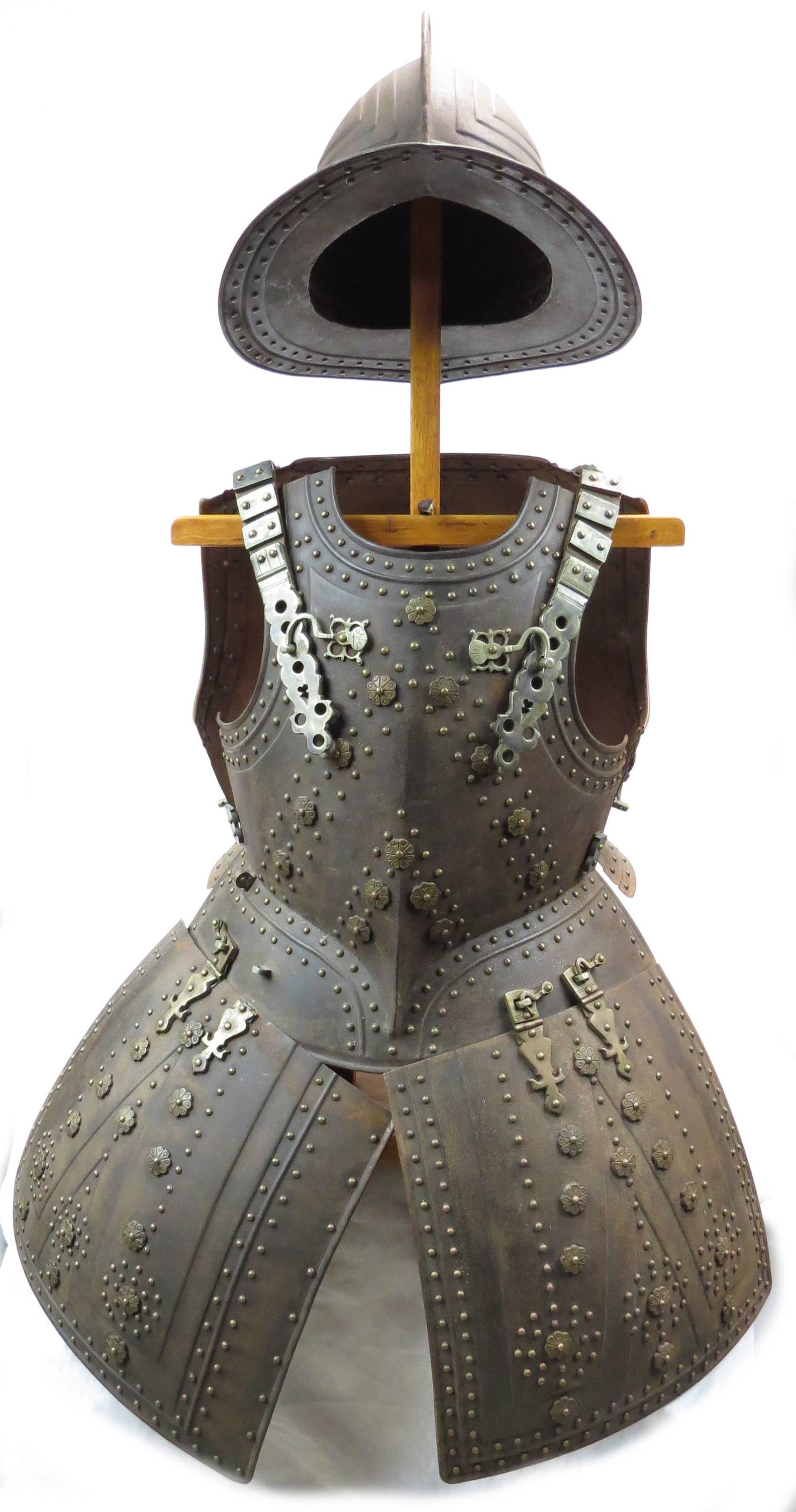 A REPLICA ENGLISH PIKEMAN’S ARMOR: Comprising a helmet, breastplate, backplate and tassets. Finely wrought of steel with embossing and brass studding overall, the hardware and shoulder straps likewise mounted in brass. 20th century. Mi