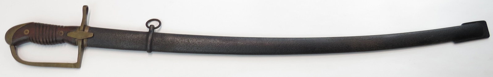 A POLISH M 1934 CAVALRY SABER: Of characteristic form, with brass hilt and wood grip. With lightly curved, fullered and spear tipped blade struck at the forte with maker’s marks, the spine numbered. In its iron scabbard. Second q