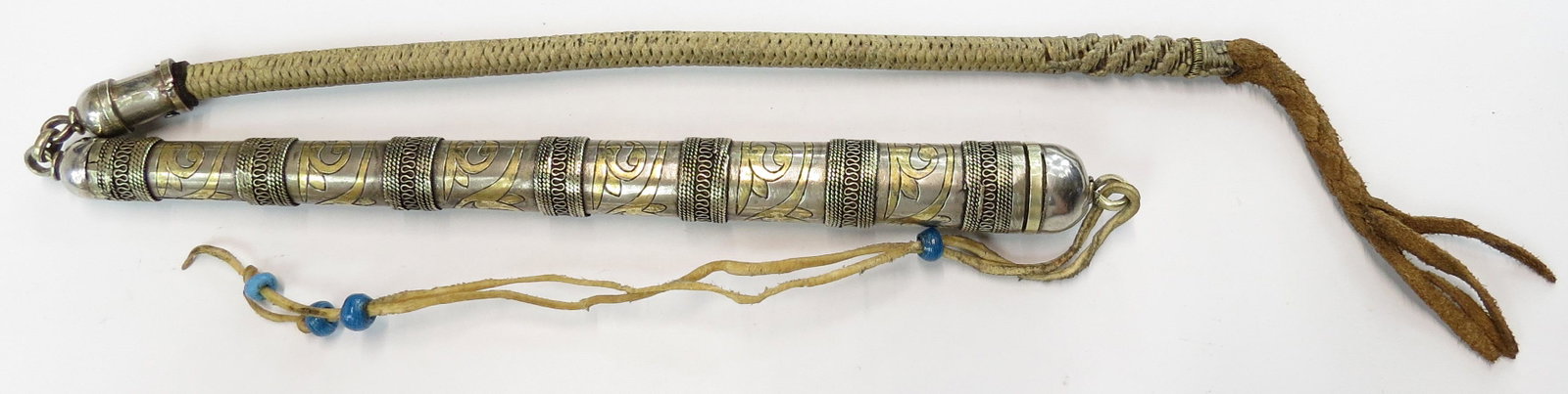 A CENTRAL ASIAN KAMCIN RIDING CROP: Tekke Turkmen People, The haft engraved and gilded, the plaited lash intact. With concealed blade and rawhide lanyard. 20th century. Minor wear. Overall length extended 74cm. Condition III