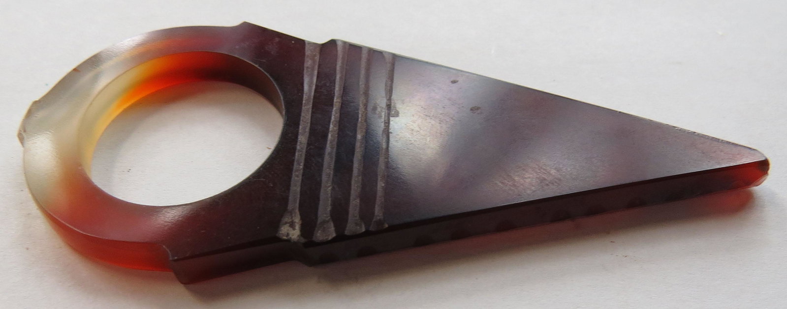 A TUAREG ARCHERS RING: Of characteristic triangular form, handground of carnelian and well-polished. 19th c. Overall length 6.7cm. Condition I