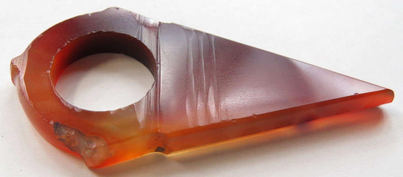 A TUAREG ARCHERS RING: Of characteristic triangular form, handground of Carnelian and well-polished. 19th c. Overall length 6.1cm. Condition I