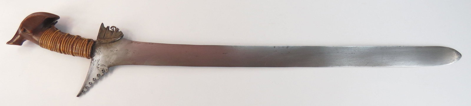 A MORO DATUS KRIS SWORD: Likely Maguindanao work, with carved hardwood kakatua-form pommel and rattan-wrapped grip. A single baca-baca retains the substantial blade forged with a separate ganja and showing evidence of damascu
