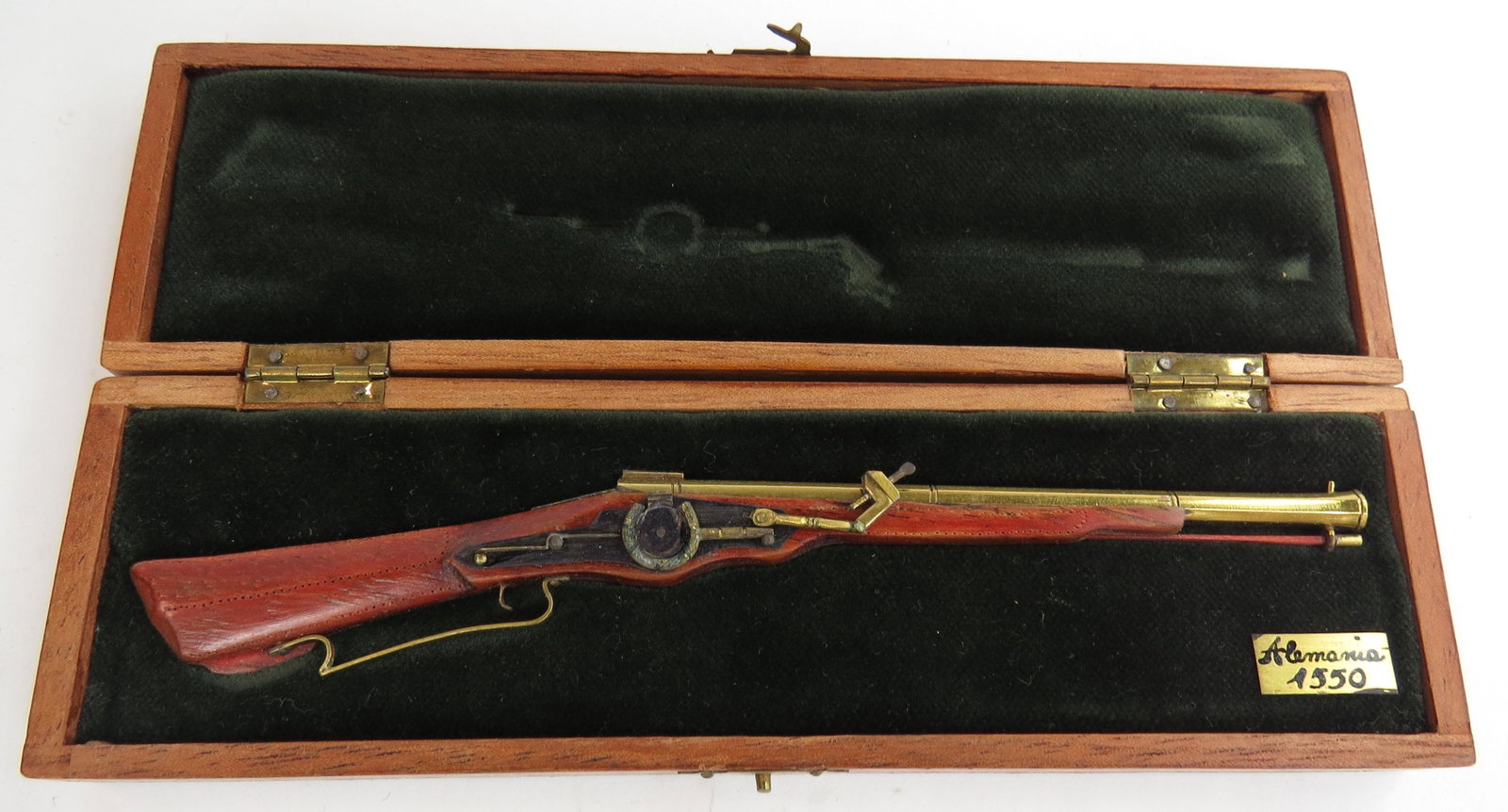 A FINE MINIATURE WHEELLOCK MUSKET BY EDUARDO RUIZ: A miniature wheellock musket made entirely by hand, the stock carved of hardwood with percussion mechanism, barrel, triggerguard and appliques all superbly detailed in metal. In its fitted handmade ha