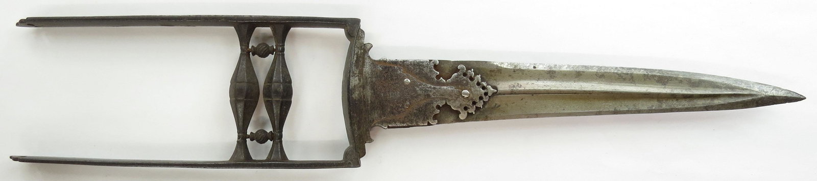 A MUGHAL KATAR DAGGER: With rare curved blade wrought of fine, actively-grained wootz and openwork grips, finely fretted base reinforce and elegant side rails with scrolled finials and openwork grips. 17th-18th century. Dar