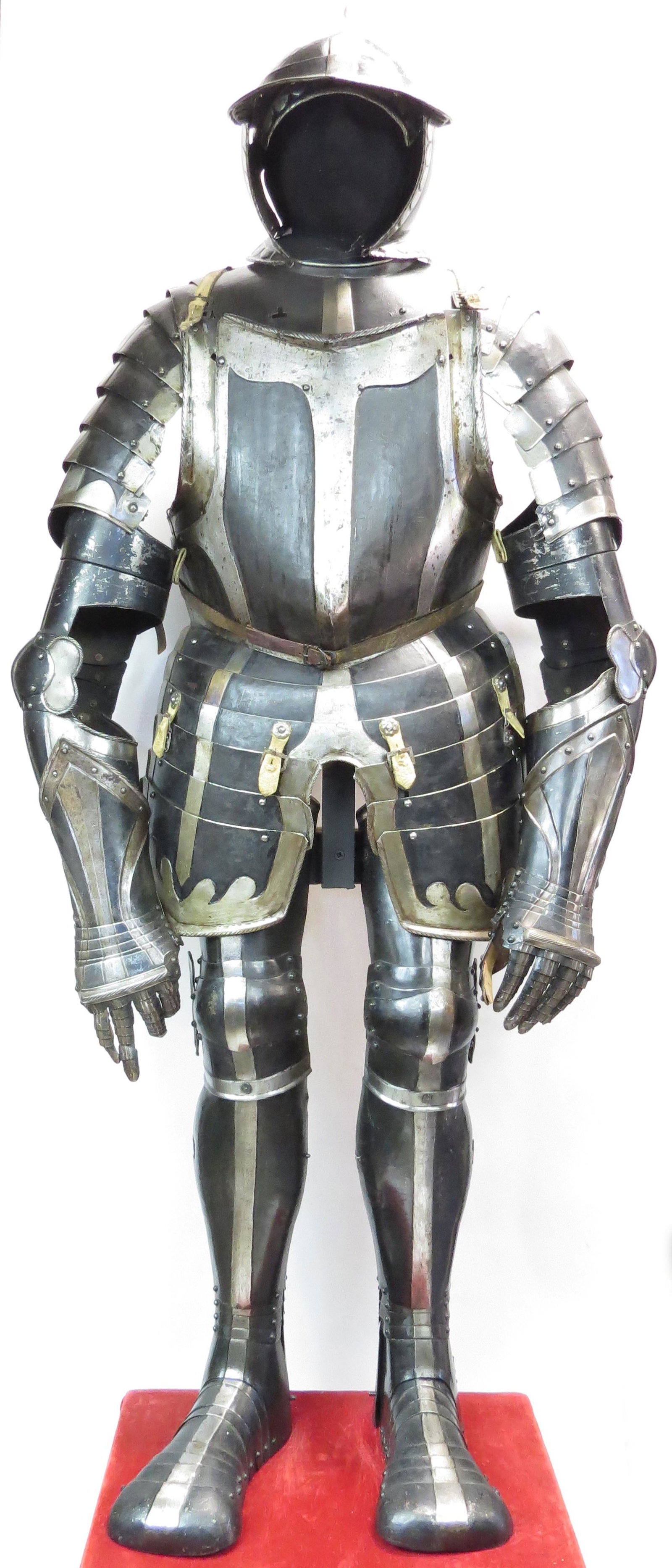 A FINE SUIT OF BLACK & WHITE ARMOR: South German or Austrian, very well maintained and retaining a smooth, bright steel surface alternating with blackened panels throughout. Comprising a fine burgonet with rare high, finely-wrought peak
