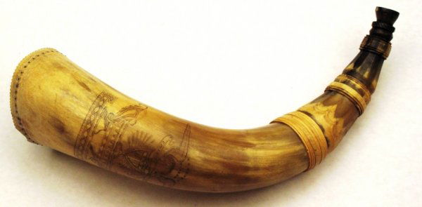 An American Revolutionary War-era Powderhorn: The body of blond cowhorn with darker mottling toward the tip, with characteristic turnings and faceting, the body finely engraved with an American Eagle surrounded by 13 stars, gripping a banner insc