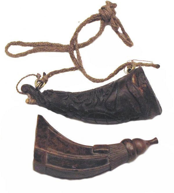 Two East Asian Powderhorns: Probably Tibetan or ethnic Chinese, both of dark horn, the first carved with panels and integral loop, the stopper formed as a lotus bud, the second carved overall with animals including a lizard and