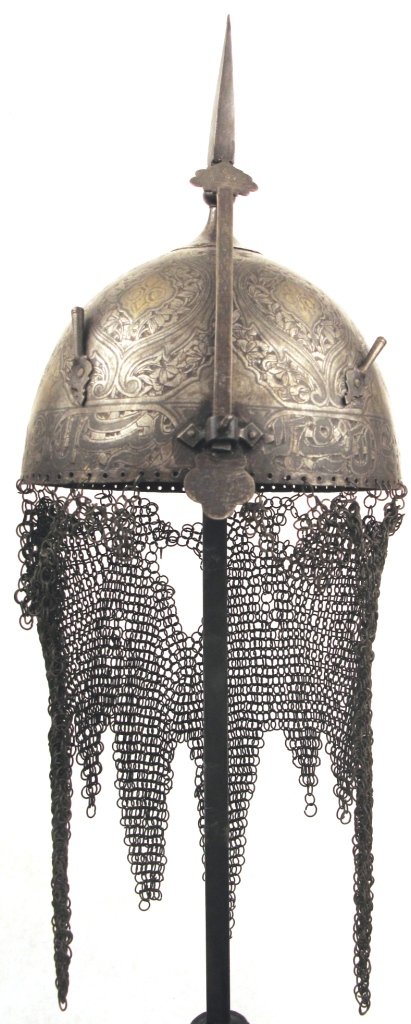 A Set of Persian Armor: Qajar Dynasty work of fine quality, comprising a helmet of classic form with vandyked camail, spiked finial, plume holders and adjustable nasal, a shield with four central bosses and applied brass rim