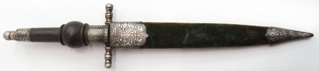 AN ANGLO-INDIAN HUNTING DAGGER: Of plug bayonet form, with turned hardwood grip and steel mounts finely inlaid in silver, with broad, straight double-edged blade inlaid in silver at the forte. In its velvet-covered wooden scabbard w