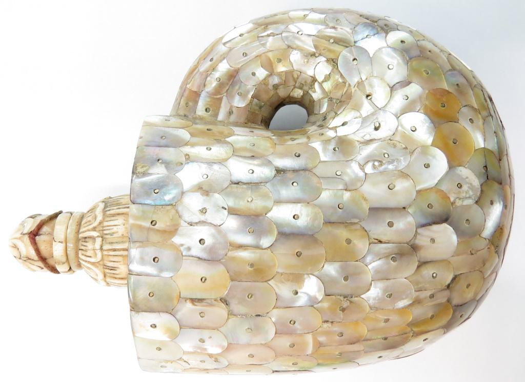 A RARE INDIAN BARUTDAN POWDERHORN: A fine example, the large body of characteristic form, covered completely in mother-of-pearl plaques in geometrical patterns. The carved bone spout retains its stopper. Latter-18th century. Overall le