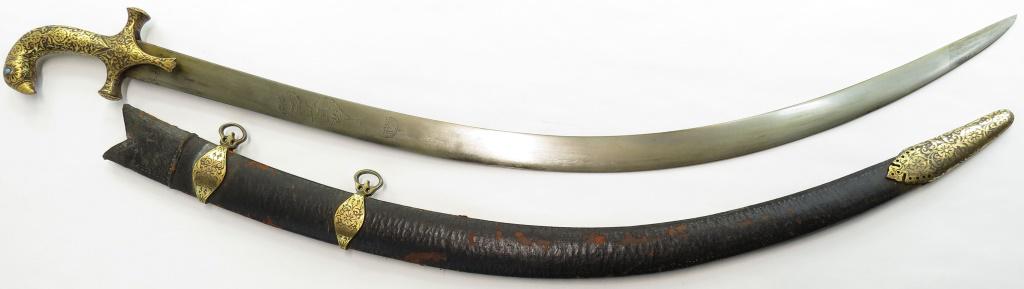 AN INDIAN SHAMSHIR SABER SWORD: Mughal work, with persianate wrought steel hilt terminating in a fully-modelled parrots head, with turquoise eyes, finely inlaid overall in complex flowering vine motifs in gold. The fine, robust Pers